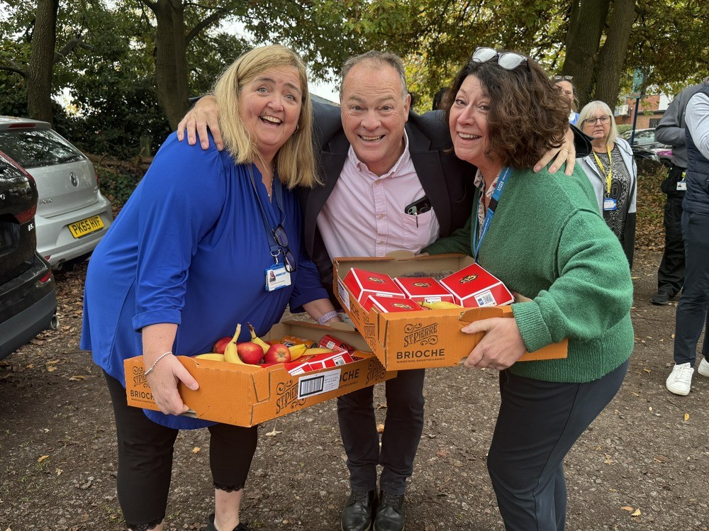 Members of hospital staff smiling holding boxes of burgers.