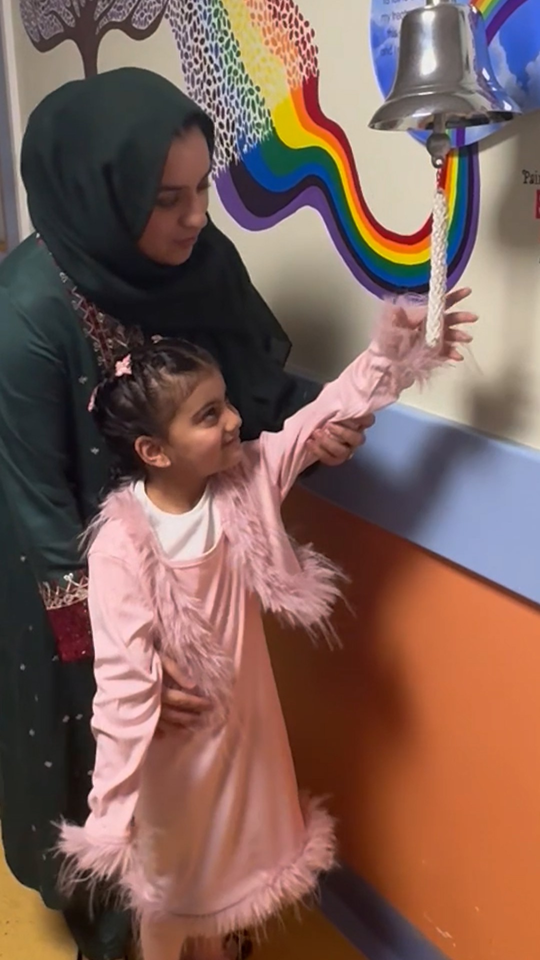 A child called Hibas rings a bell to signify the end of her cancer treatment