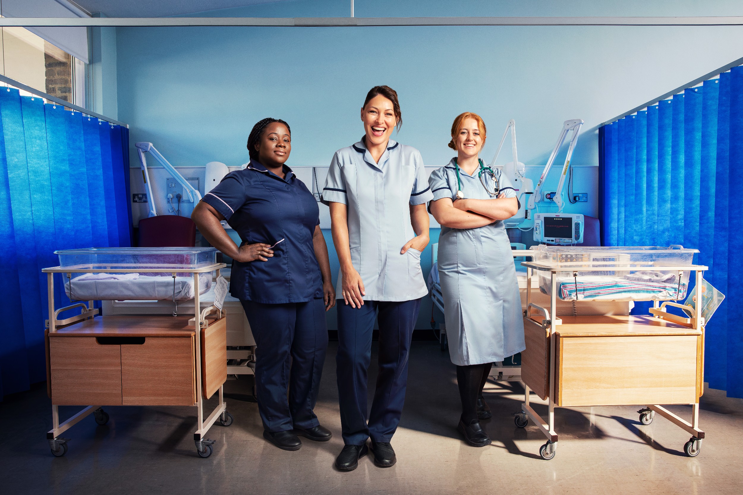 Emma Willis in between two members of staff on a hospital ward