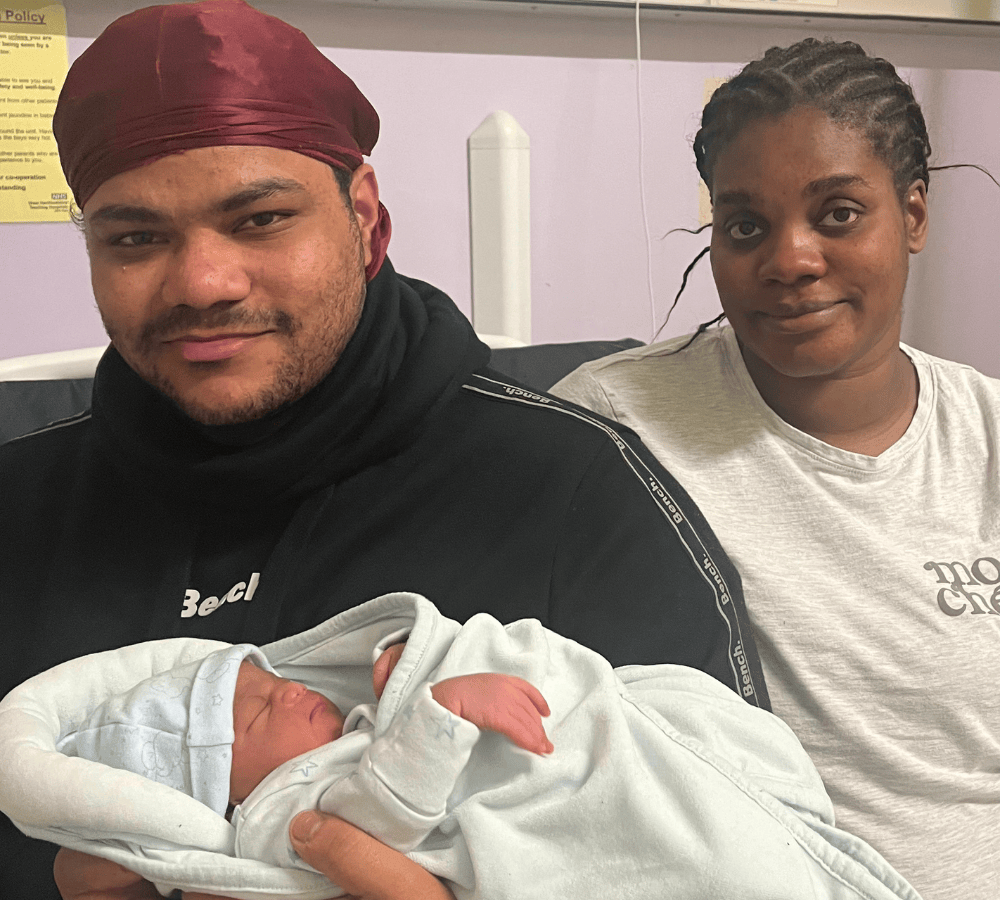 Mum and dad holding baby boy, second baby to be born on New Year's Day